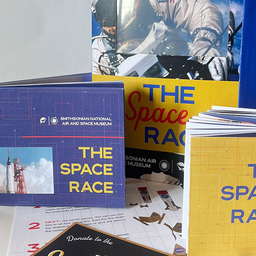 Spread of Space Race museum folder, catalog, timeline, paper rocket, and donor card